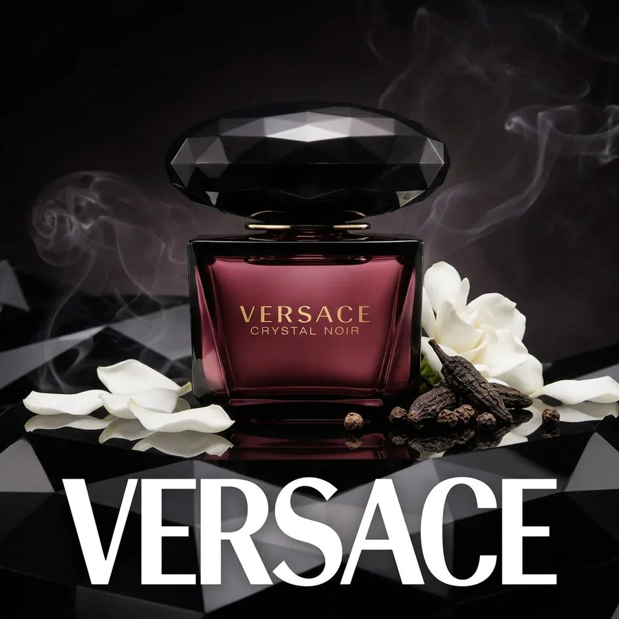 Versace Crystal Noir perfume bottle with white flower petals and spices on a black background