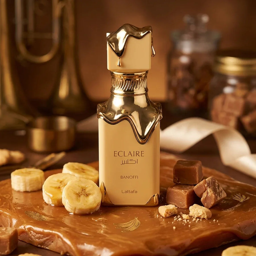 Lattafa Eclaire Banoffi perfume bottle with gold accents, surrounded by banana slices and caramel cubes.