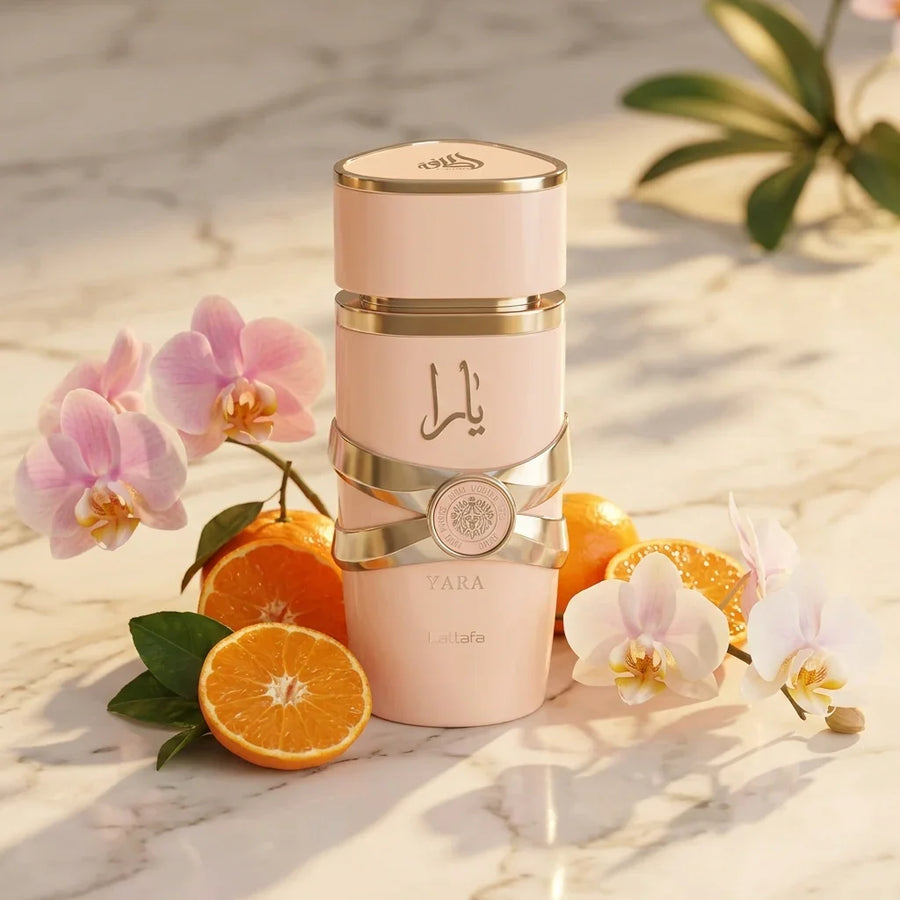 Yara perfume bottle with gold accents, surrounded by orchids and fresh oranges on marble.