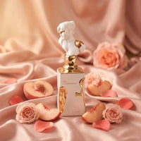 Luxury Her Confession perfume bottle with gold accents, surrounded by roses and peach slices