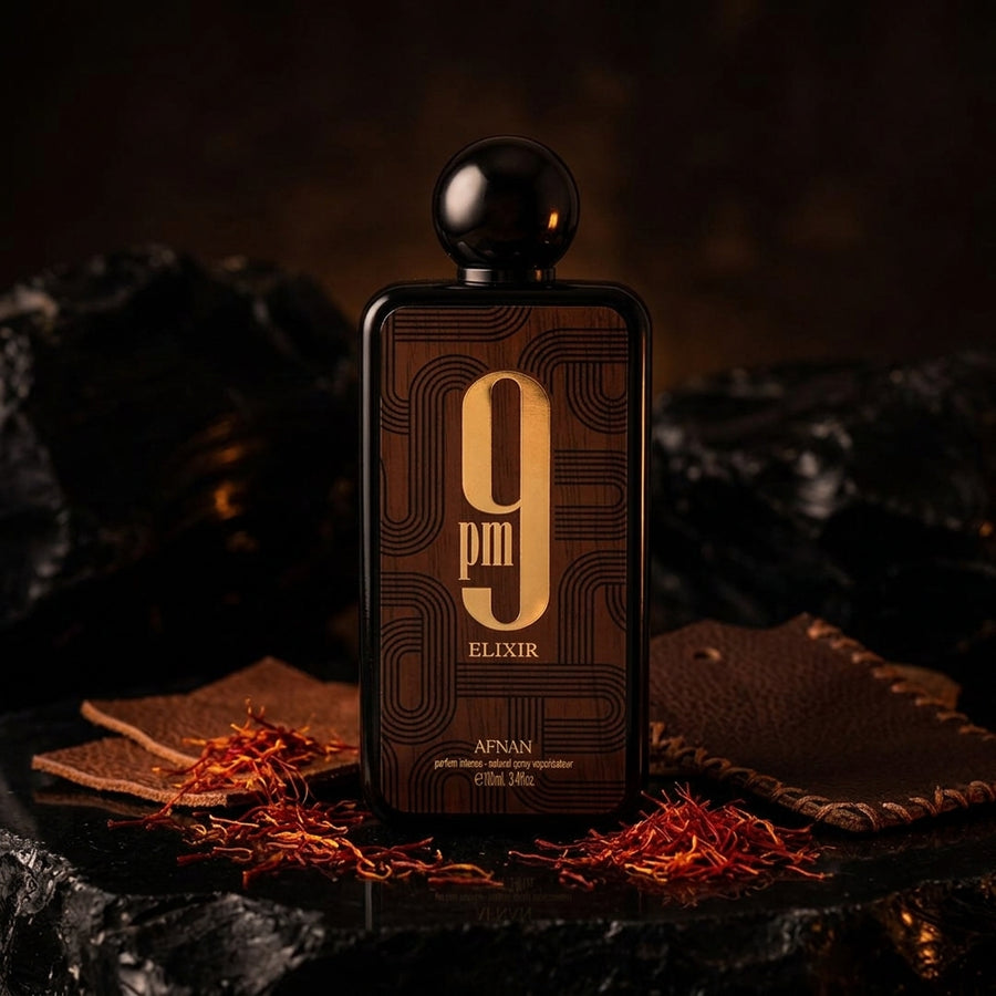 Afnan 9pm Elixir perfume bottle with saffron and leather props in a dark, elegant setting.